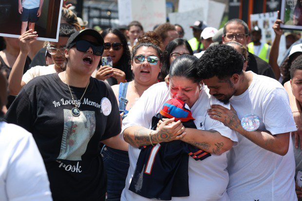 Vanessa Rivera, second from right, holds a Spider-Man toy as she is comforted during a march for peace on West Jackson Boulevard in Chicago on June 21, 2024, near the Oakley Square apartment complex where her nephew Jai'Mani Amir Rivera was killed Tuesday. (Terrence Antonio James/Chicago Tribune)