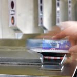 A photo of a human hand swiping a MetroCard at a New York City subway stations.