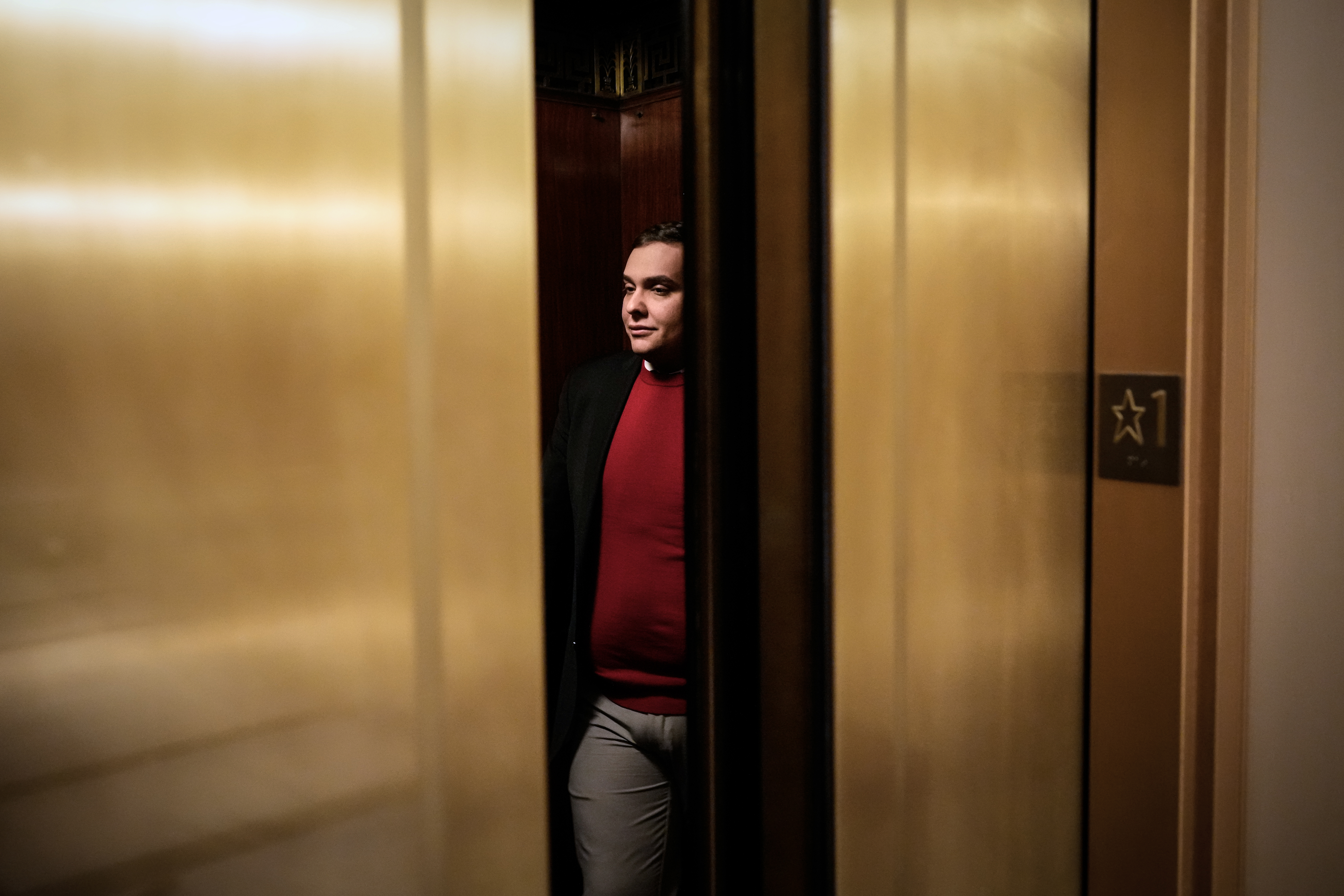 Rep. George Santos stands in an elevator as the doors frame his silhouette.