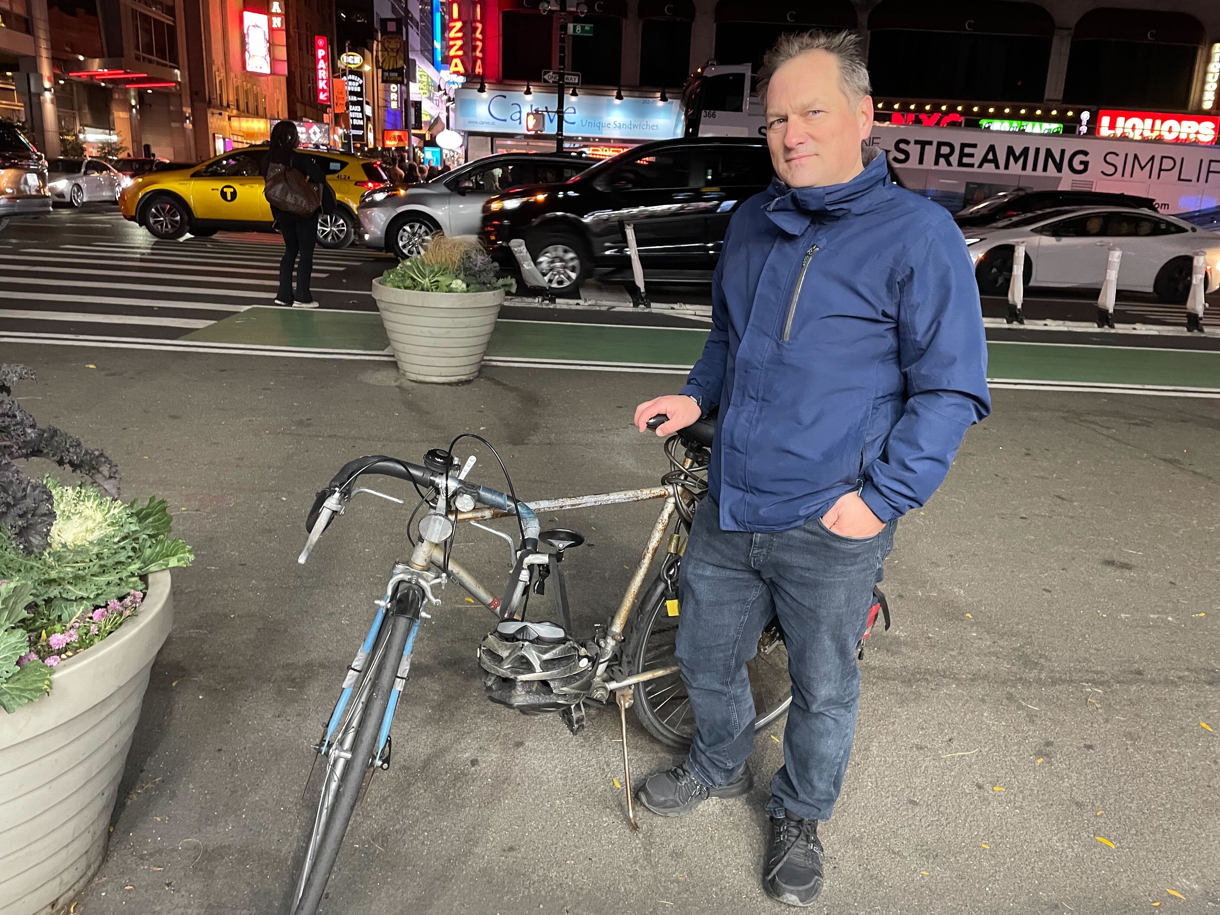 A man stands by his bicycle in Times Square.