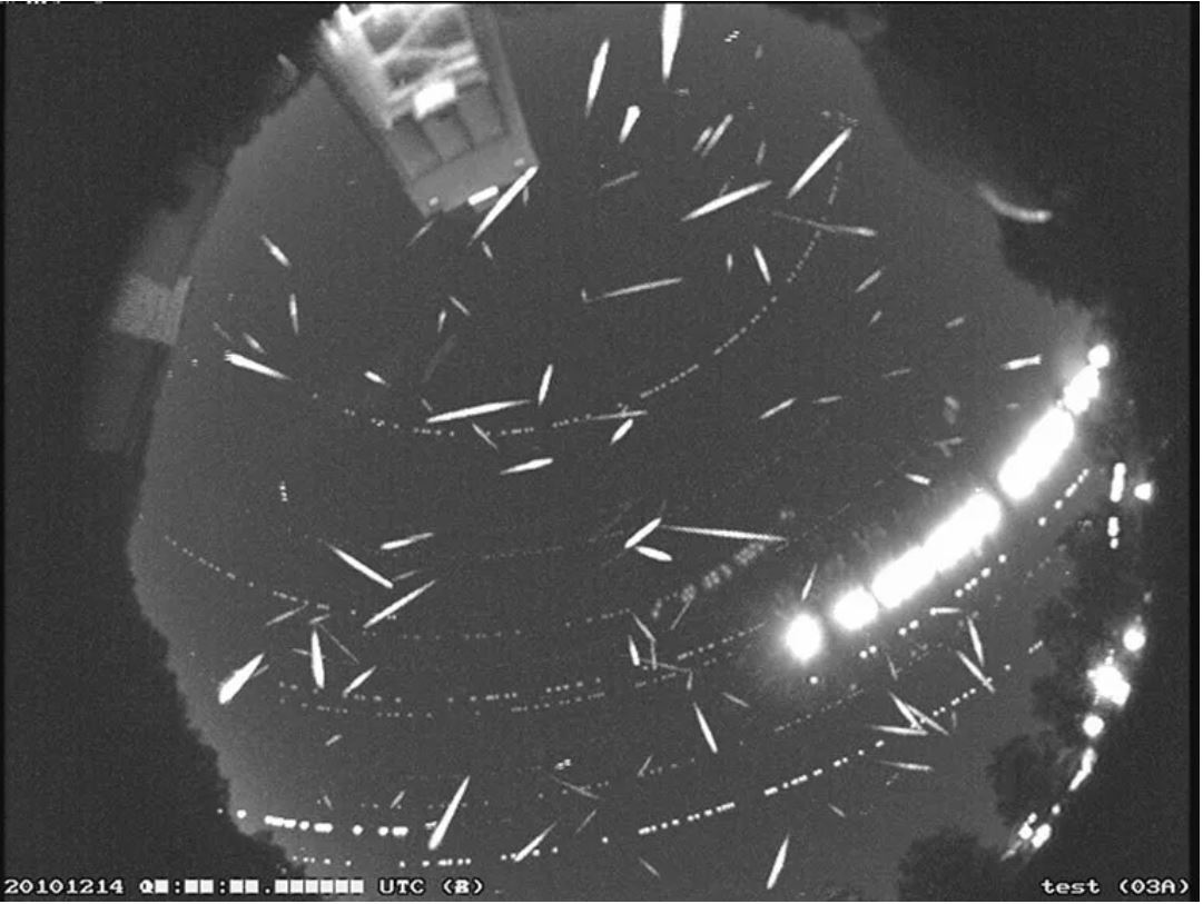 A composite black and white photo of a meteor shower taken by NASA.