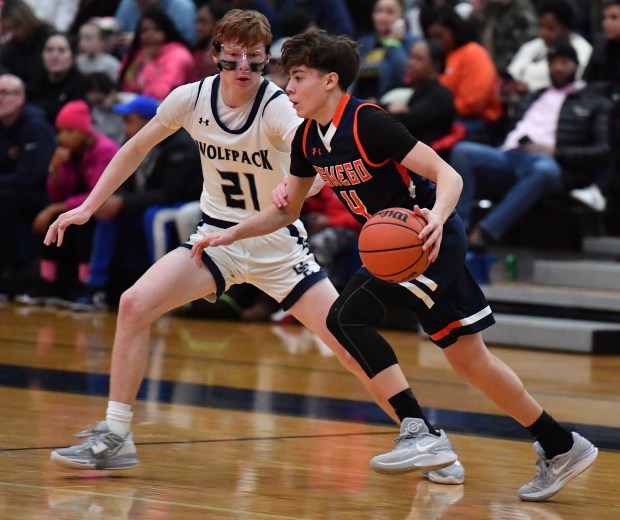 Oswego's Mariano Velasco (4) drives as Oswego East's Andrew Pohlman (21) defends during a game in Oswego on Tuesday, February 13, 2024.(Jon Cunningham for The Beacon-News)