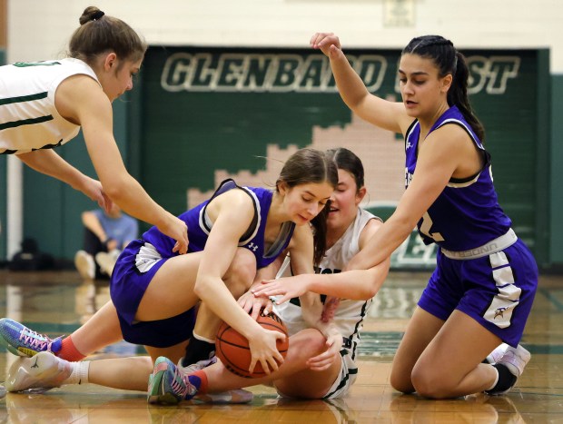 Geneva's Hope Ieler, Leah Palmer and Glenbard West's Makenna Yeager scramble for a loose ball during the girls Class 4A Regional final basketball game in Glen Ellyn, Ill Thursday, February 15, 2024. (James C. Svehla-Beacon News)
