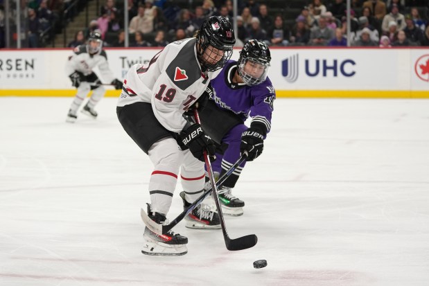 Ottawa forward Brianne Jenner (19) and Minnesota defender Sophie Jaques vie for the puck during a PWHL game on Feb. 14, 2024, in St. Paul, Minn. (AP Photo/Abbie Parr)