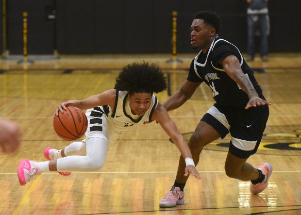 Mount Carmel's Grant Best (3) lays in a basket against Hyde Park's Marquise Merritt (2) during the Class 3A Hinsdale South Sectional semifinals Tuesday, February 27, 2024 in Darien, IL. (Steve Johnston/Daily Southtown)
