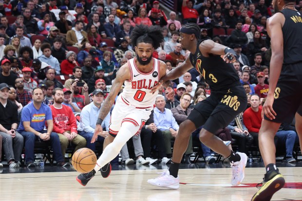 Bulls guard Coby White (0) dribbles around Cavaliers guard Caris LeVert on Feb. 28, 2024, at the United Center. (Terrence Antonio James/Chicago Tribune)
