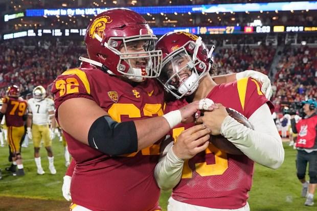 Southern California quarterback Caleb Williams, right, gets a hug from offensive lineman Brett Neilon after USC defeated Notre Dame 38-27 an NCAA college football game Saturday, Nov. 26, 2022, in Los Angeles. (AP Photo/Mark J. Terrill)