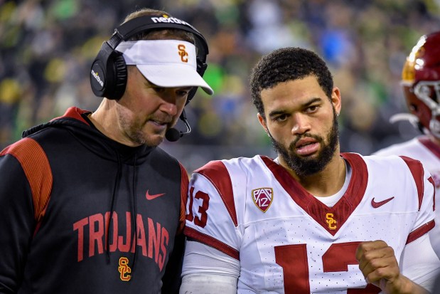 Southern California coach Lincoln Riley and quarterback Caleb Williams (13) confer during the first half of the team's NCAA college football game against Southern California on Saturday, Nov. 11, 2023, in Eugene, Ore. (AP Photo/Andy Nelson)