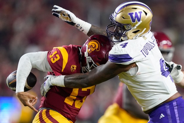 Washington defensive end Zion Tupuola-Fetui, right, forces a fumble by USC quarterback Caleb Williams during the first half on Nov. 4, 2023, in Los Angeles.