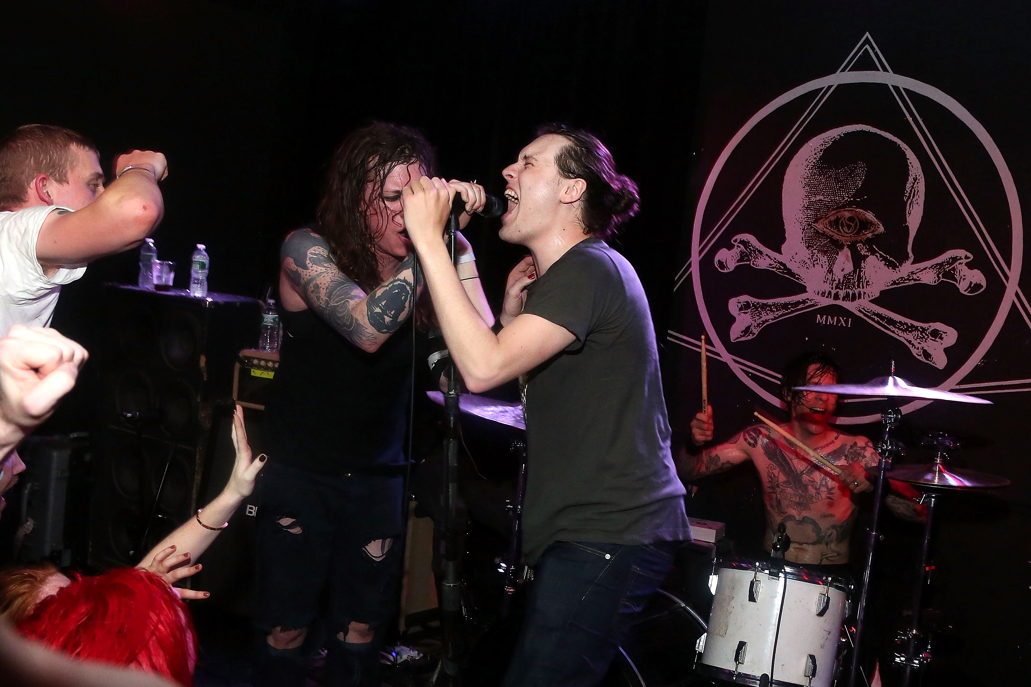 Laura Jane Grace sings with a fan onstage as Against Me! performs during a secret aftershow party at Brooklyn's Saint Vitus Bar on May 4, 2014.