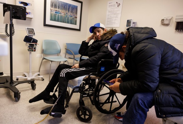 Marilieser Gil-Blanco, center, waits with his cousin Jefferson Cañizalez for a medical appointment at Northwestern Memorial Hospital on Feb. 6, 2024, in Chicago. (Armando L. Sanchez/Chicago Tribune)