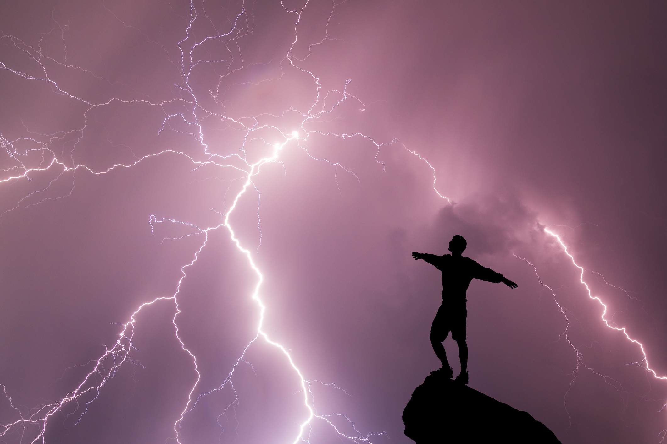 a guy standing outside during a lightning storm
