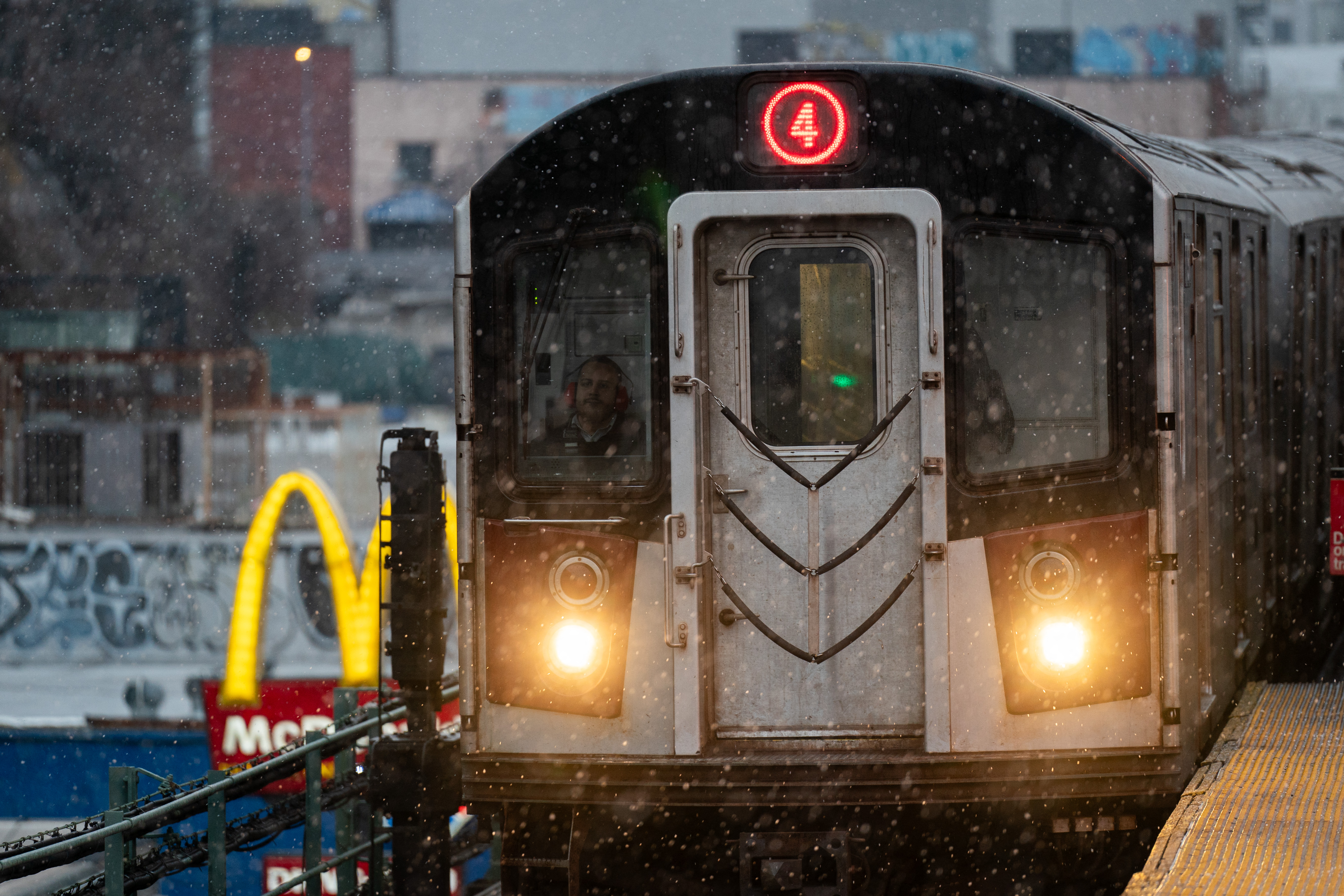 A 4 Subway train operates during snowfall in the Bronx.