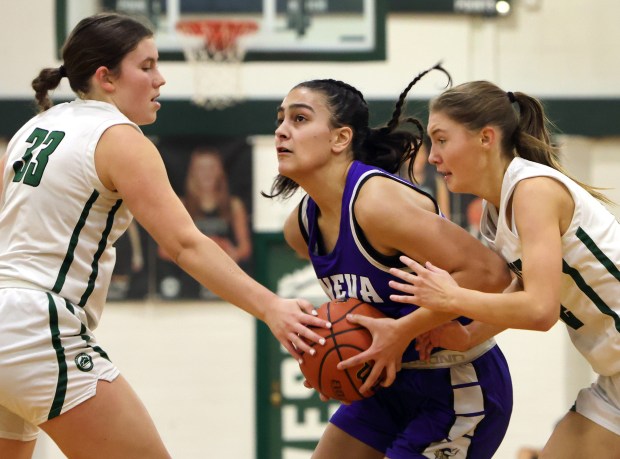 Geneva's Leah Palmer drives for the basket as Glenbard West's Makenna Yeager and Lily Hubbuch defend during the girls Class 4A Regional final basketball game in Glen Ellyn, Ill Thursday, February 15, 2024. (James C. Svehla-Beacon News)