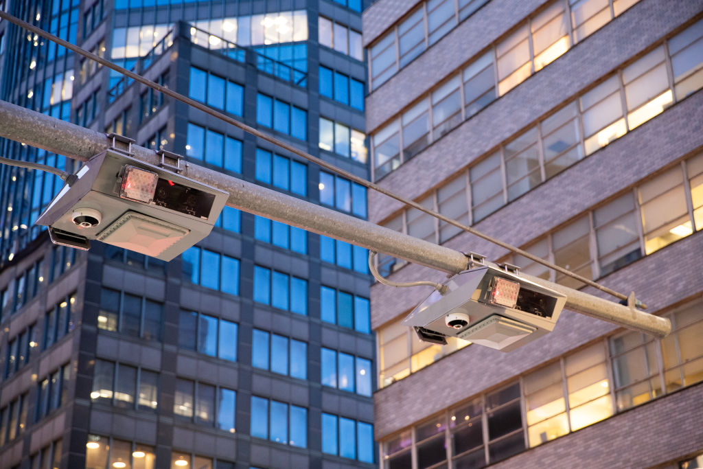 Camera boxes with special readers hang over a Manhattan street.