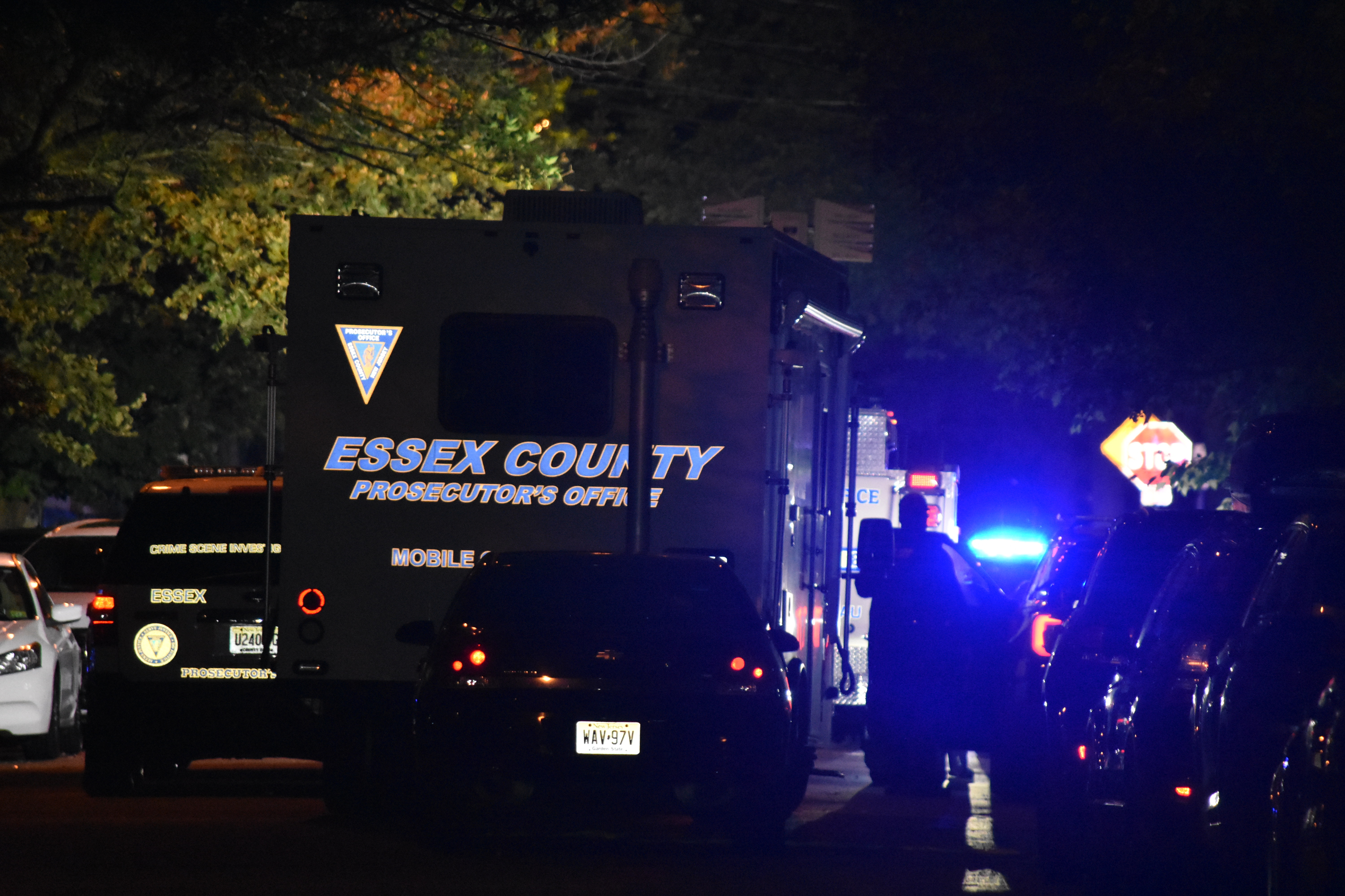 Police vehicles with their emergency lights on at night respond to a crime in Newark.