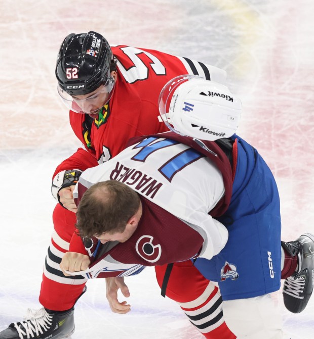 Avalanche right wing Chris Wagner's helmet flies off as he fights Blackhawks center Reese Johnson (52) in the second period on Feb. 29, 2024, at the United Center. (John J. Kim/Chicago Tribune)
