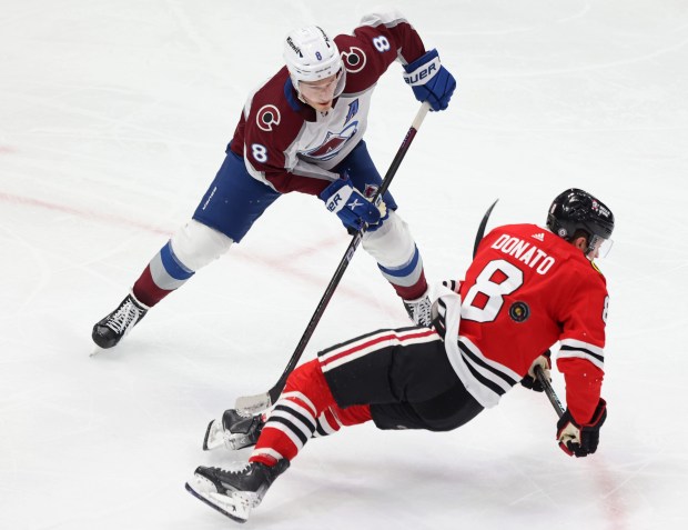 Blackhawks center Ryan Donato (8) falls to the ice while advancing the puck against Avalanche defenseman Cale Makar in the third period on Feb. 29, 2024, at the United Center. (John J. Kim/Chicago Tribune)
