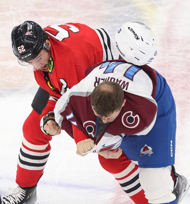 Blackhawks center Reese Johnson (52) and Avalanche right wing Chris Wagner fight in the second period on Feb. 29, 2024, at the United Center. (John J. Kim/Chicago Tribune)