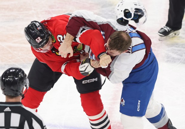 Avalanche right wing Chris Wagner's helmet flies off as he fights Blackhawks center Reese Johnson in the second period on Feb. 29, 2024, at the United Center. (John J. Kim/Chicago Tribune)