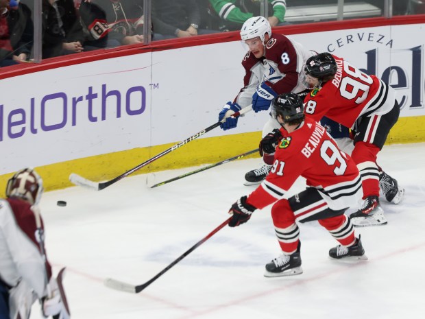 Blackhawks center Connor Bedard (98) reaches for the puck as Avalanche defenseman Cale Makar (8) passes in the first period on Feb. 29, 2024, at the United Center. (John J. Kim/Chicago Tribune)