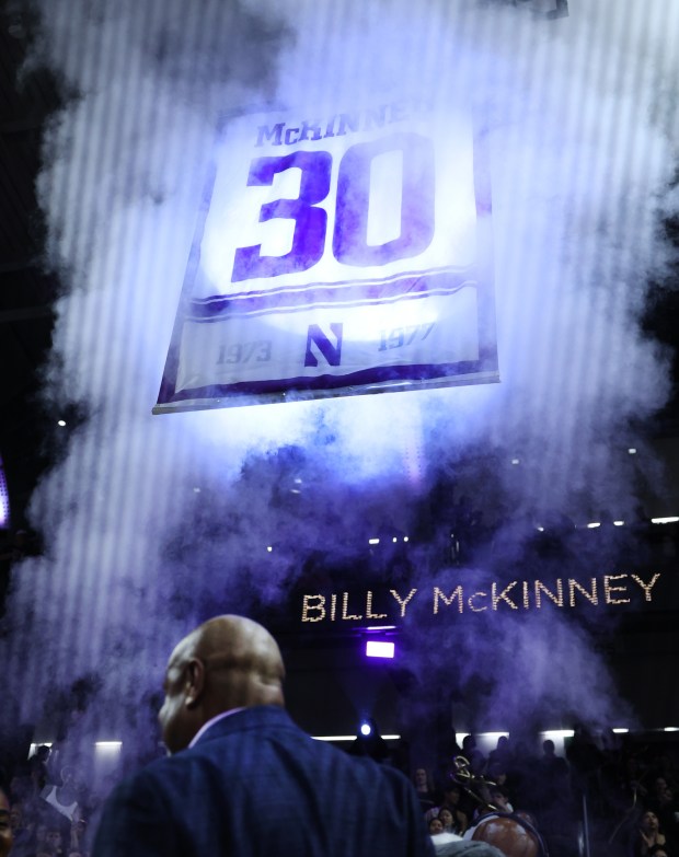 Former Northwestern player Billy McKinney stands on the floor as his No. 30 is raised up during a ceremony to retire his number at halftime of a game between Northwestern and Iowa at Welsh-Ryan Arena in Evanston on March 2, 2024. (Chris Sweda/Chicago Tribune)