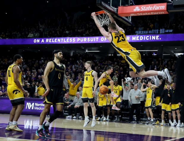 Iowa forward Ben Krikke dunks in front of Northwestern guard Boo Buie in the second half on March 2, 2024, at Welsh-Ryan Arena in Evanston. (Chris Sweda/Chicago Tribune)