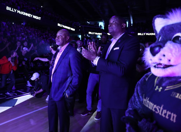 Former Northwestern great Billy McKinney, left, stands on the floor as his No. 30 is raised up to the rafters during a halftime ceremony at Welsh-Ryan Arena in Evanston on March 2, 2024. (Chris Sweda/Chicago Tribune)