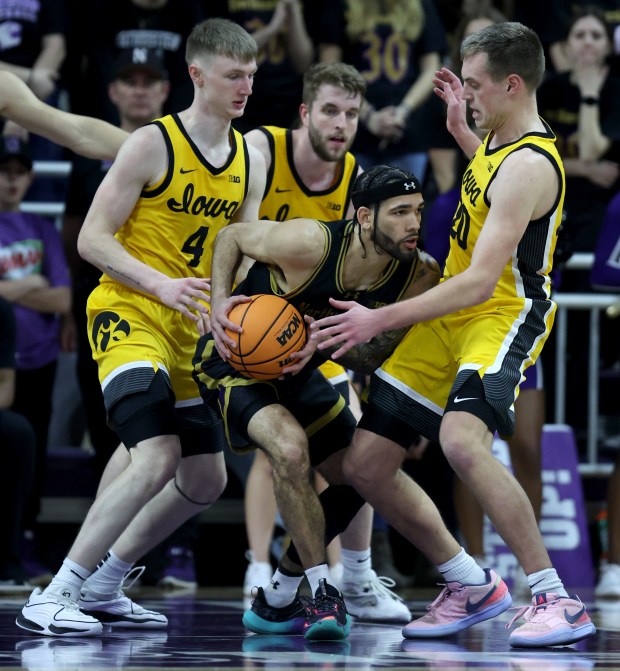 Northwestern guard Boo Buie (0) looks for an open teammate as Iowa players surround him in the second half of a game at Welsh-Ryan Arena in Evanston on March 2, 2024. (Chris Sweda/Chicago Tribune)