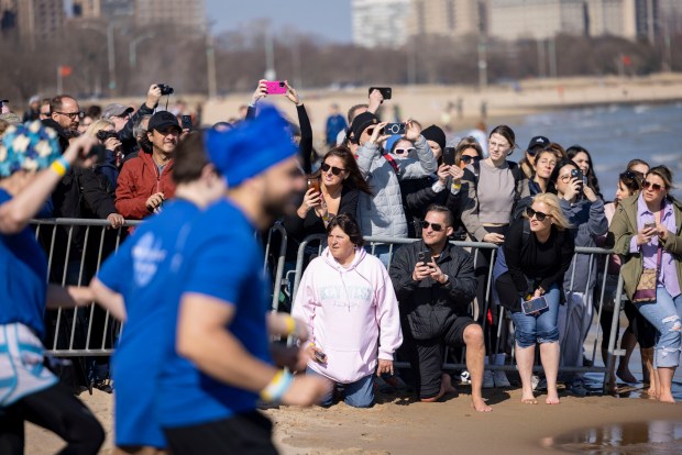 Spectators watch as participants take a dip in Lake Michigan on a warm morning during the 24th Annual Chicago Polar Plunge, Sunday, March 3, 2024, at North Avenue Beach. (Brian Cassella/Chicago Tribune)