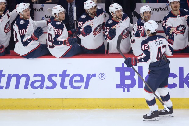 Columbus Blue Jackets' Alexandre Texier (42) celebrates with teammates at the bench after scoring during the first period of an NHL hockey game against the Chicago Blackhawks Saturday, March 2, 2024, in Chicago. (AP Photo/Paul Beaty)