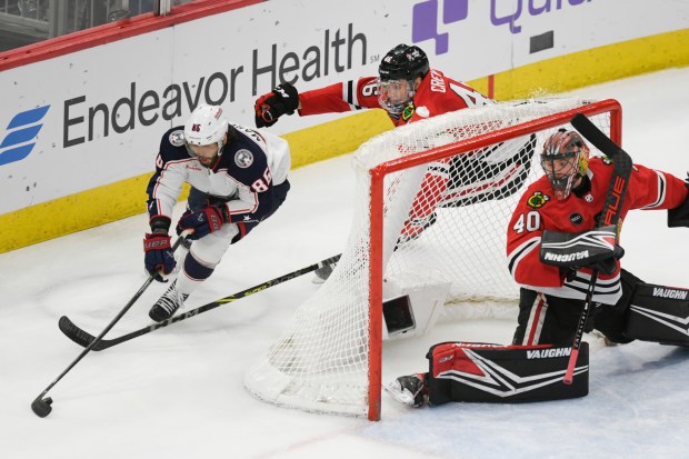 Columbus Blue Jackets' Kirill Marchenko (86) moves the puck against Chicago Blackhawks' Louis Crevier (46) and goalie Arvid Soderblom (40) during the second period of an NHL hockey game Saturday, March 2, 2024, in Chicago. (AP Photo/Paul Beaty)