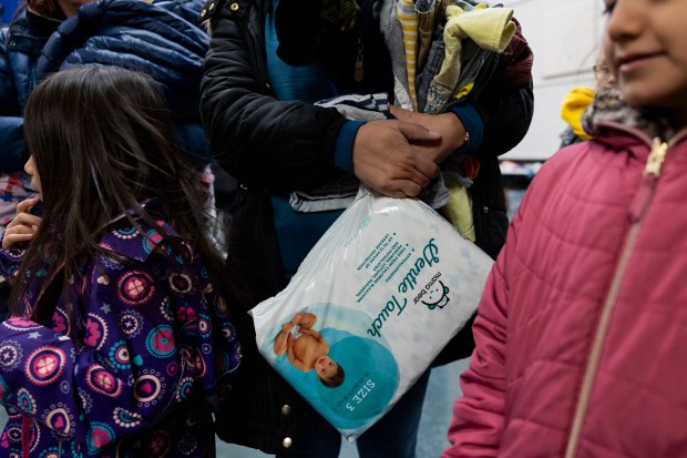 Any Sanchez holds a package of diapers on Feb. 24, 2024, at a supply drive called "Freebies for Families" hosted by Southwest Collective at Edwards Elementary in Chicago. (Vincent Alban/Chicago Tribune)