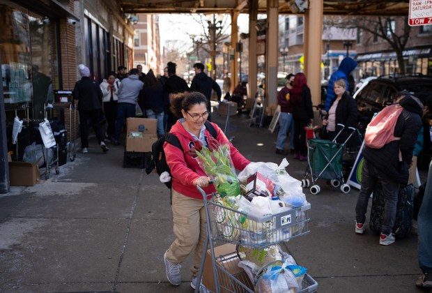 Vicenta Buitrago leaves Nourishing Hope-Sheridan Market with her food items on Monday, Feb. 26, 2024. Food pantries in Chicago are struggling to meet demand with the influx of migrants in the city. (E. Jason Wambsgans/Chicago Tribune)