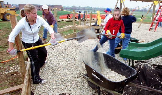 Volunteers load crushed stone into wheelbarrows Oct. 16, 1999, as community members come together to build the Fort Frankfort playground at Sauk Trail and 80th Avenue in Frankfort. Nearly a quarter century later, the playground will get a major update thanks to a $1.7 million state grant. (John Smierciak/Chicago Tribune)