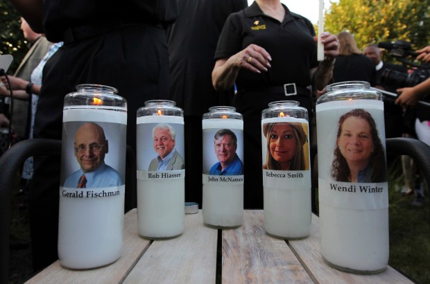 Five employees of the Capital Gazette newspaper adorn candles on June 29, 2018, during a vigil across the street from where they were slain in the newsroom in Annapolis, Md. (Jose Luis Magana/AP)