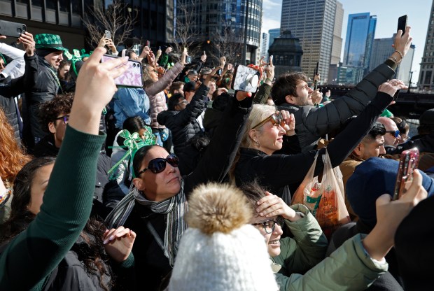 Spectators record as the Chicago River is dyed green to celebrate St. Patrick's Day on March 16, 2024. (Vincent Alban/Chicago Tribune)