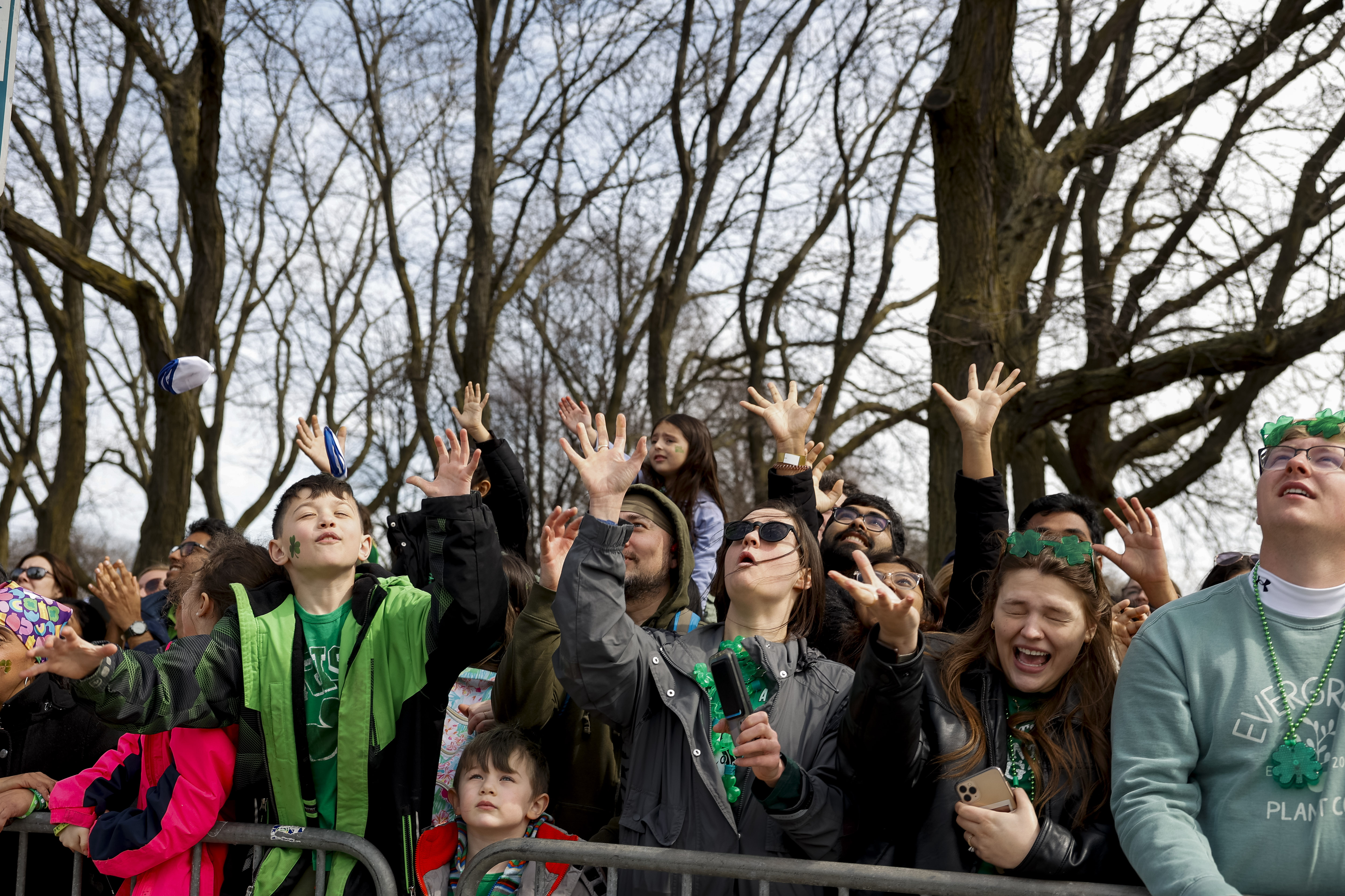 Spectators attempt to catch give away items during the annual St. Patrick's Day Parade on March 16, 2024, on in Chicago. (Vincent Alban/Chicago Tribune)