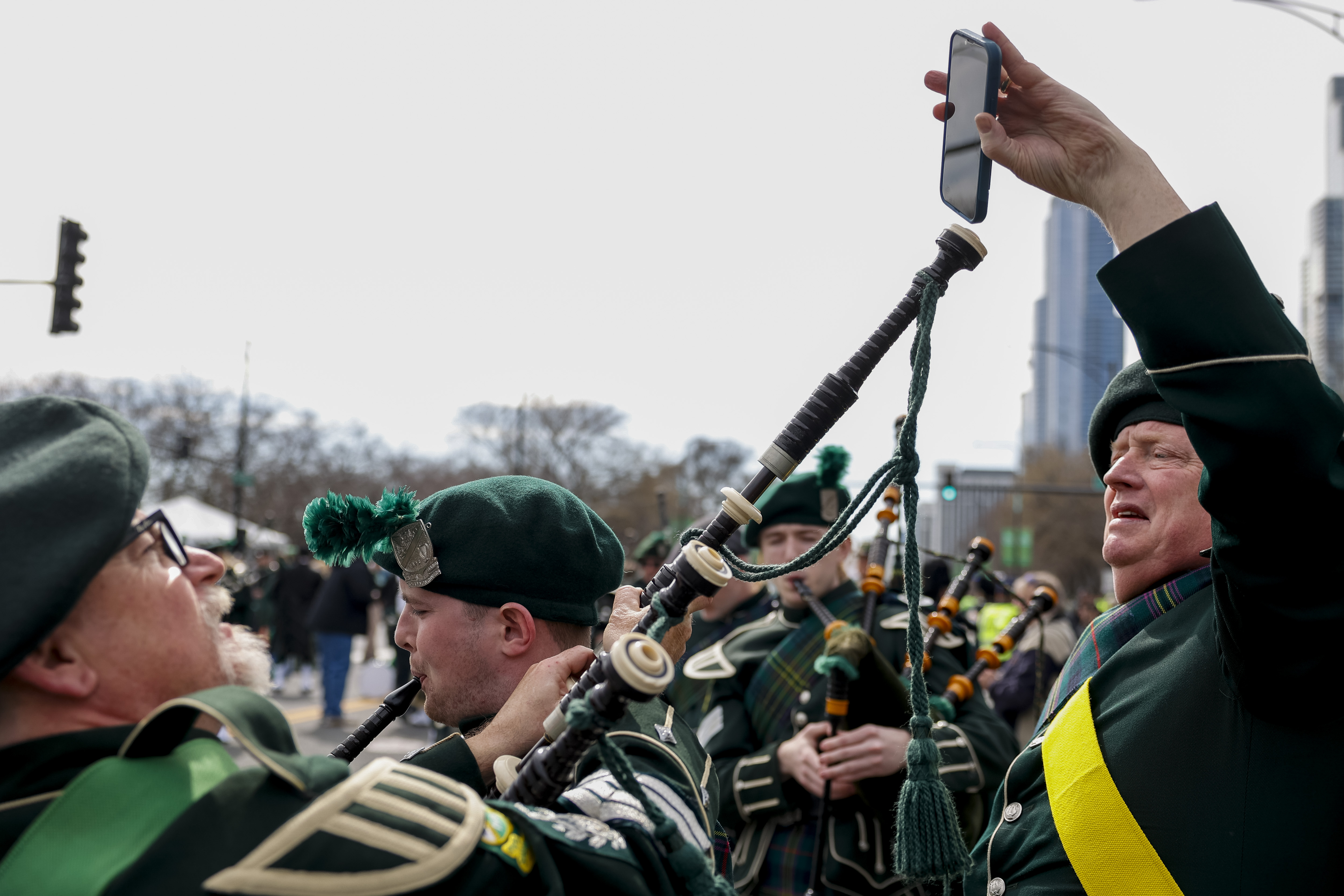 Members of the Shannon Rovers tune the bagpipes of Emmett Brown, center, before the annual St. Patrick's Day Parade on March 16, 2024, on Columbus Drive in Chicago. (Vincent Alban/Chicago Tribune)