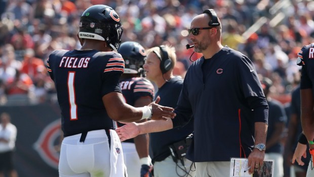 Bears coach Matt Nagy talks to quarterback Justin Fields in the fourth quarter against the Bengals on Sept. 19, 2021, at Soldier Field.