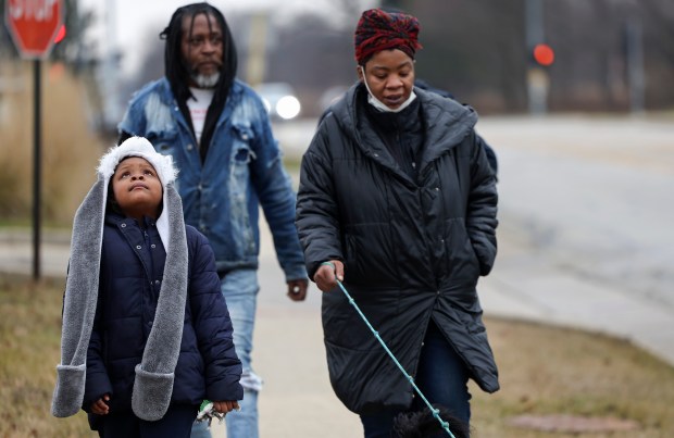 Ke'Asia Kelly, left, walks with her mother, Kiana Kelly, right, and her father, Fredrick Bass, to the McDonald's near their apartment in Highland Park on Jan. 3, 2024. (Eileen T. Meslar/Chicago Tribune)