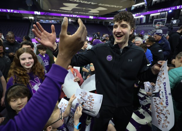 Northwestern Wildcats forward Nick Martinelli (2) high-fives a fan while signing autographs after the Northwestern Men's Basketball NCAA selection show watch party at Welsh-Ryan Arena in Evanston on Sunday, March 17, 2024. The Northwestern Wildcats will face Florida Atlantic University in the first round of the NCAA Tournament. (Trent Sprague/Chicago Tribune)