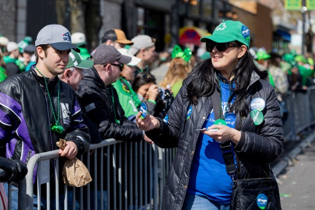 Mariyana Spyropoulos, candidate for the Cook County Clerk of the Circuit Court in Illinois, hands out campaign stickers to the crowd during the 46th South Side Irish St. Patrick's Day Parade on Sunday, March 17, 2024, on Western Ave. in Chicago. (Vincent Alban/Chicago Tribune)