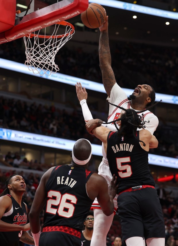 Chicago Bulls center Andre Drummond (3) dunks over Portland Trail Blazers center Duop Reath (26) and guard Dalano Banton (5) in the first half Monday, March 18, 2024, at the United Center. (Brian Cassella/Chicago Tribune)