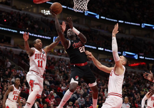 Portland Trail Blazers center Duop Reath (26) shoots between Chicago Bulls forward DeMar DeRozan (11) and center Nikola Vucevic (9) in the second half Monday, March 18, 2024, at the United Center. (Brian Cassella/Chicago Tribune)