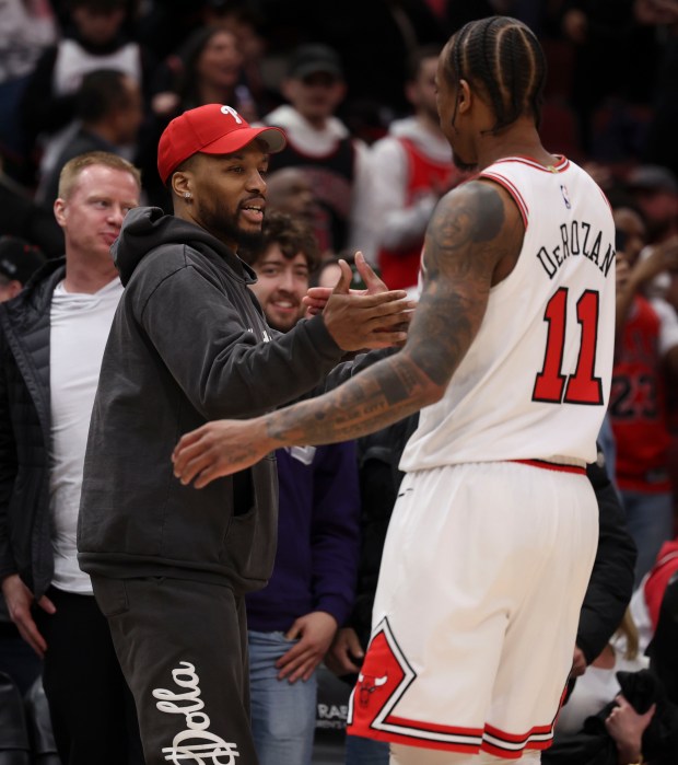Milwaukee Bucks point guard Damian Lillard, who watched the game courtside, greets Chicago Bulls forward DeMar DeRozan (11) after the win Monday, March 18, 2024, at the United Center. (Brian Cassella/Chicago Tribune)