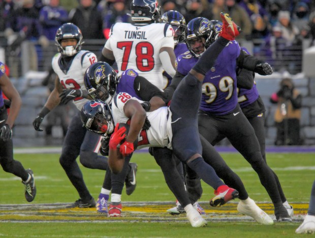 The Ravens' Jadeveon Clowney tackles Texans running back Devin Singletary during an AFC playoff game on Jan. 20, 2024, in Baltimore. (Karl Merton Ferron/Baltimore Sun)