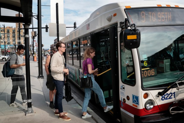 Commuters line up and board their #9, CTA Ashland Avenue bus near Belmont in Chicago, Wednesday, Oct. 4, 2023. Commuters are facing steep cuts on the CTA Orange and Brown train lines as well as some bus routes. (Antonio Perez/ Chicago Tribune)
