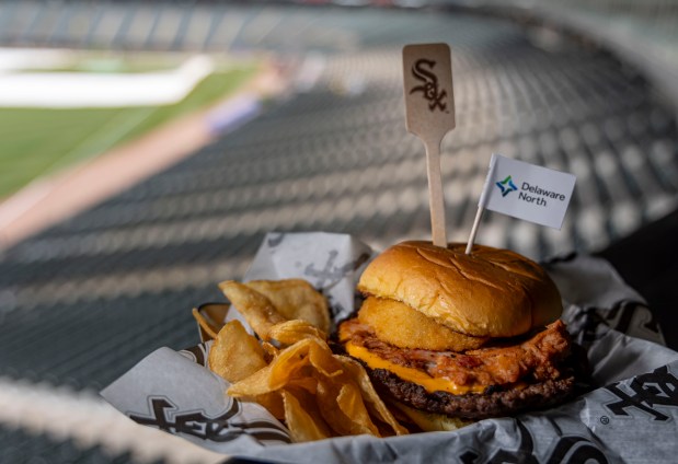 The Smoke House Smash Burger with pulled pork, BBQ sauce, beer cheese sauce and an onion ring available at the ChiSox Bar & Grill as the White Sox preview new food offerings Thursday, March 21, 2024, at Guaranteed Rate Field. (Brian Cassella/Chicago Tribune)