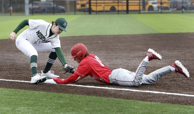 T.F. South's Jake Stachelski slides back to third base as Evergreen Park's Jack Hughes tries to make tag during a South Suburban Conference crossover in Evergreen Park on Monday, April 4, 2022.